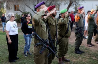 Members of Israeli Defense Forces salute during a memorial to commemorate the two-year anniversary of the deadly 7 October 2023 attack on Israel by Hamas